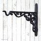 A black wrought iron decorative wall bracket with ornate scrollwork, mounted 
