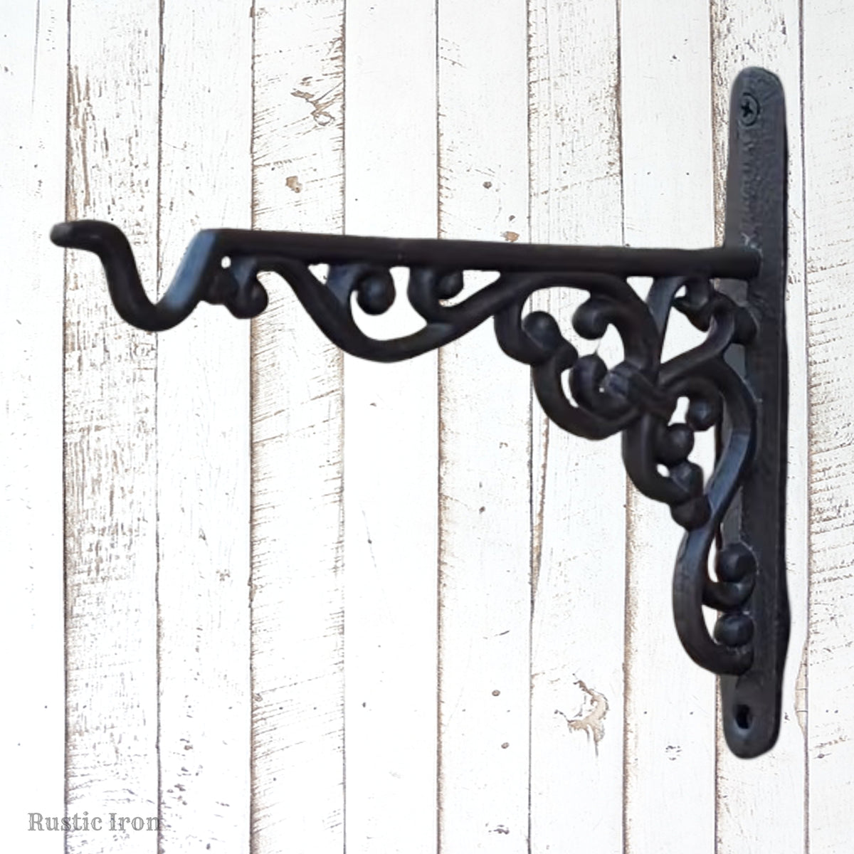 A black wrought iron decorative wall bracket with ornate scrollwork, mounted 