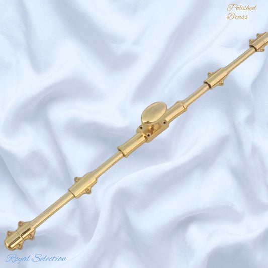 A polished brass decorative rod or finial with ornate ends and a central oval knob, .