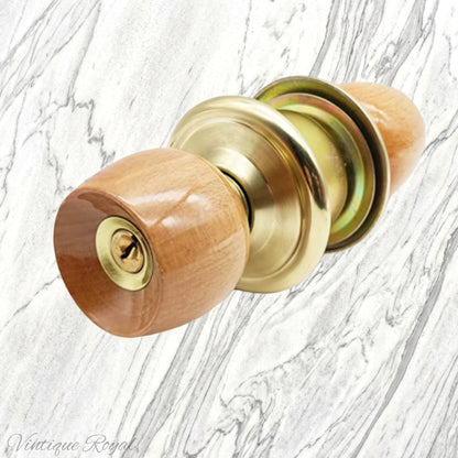 Birch wood door knob with a shiny gold base and lock mechanism, set against a marble background.