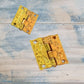 Two ornate gold-toned decorative hinges with embossed floral scrollwork