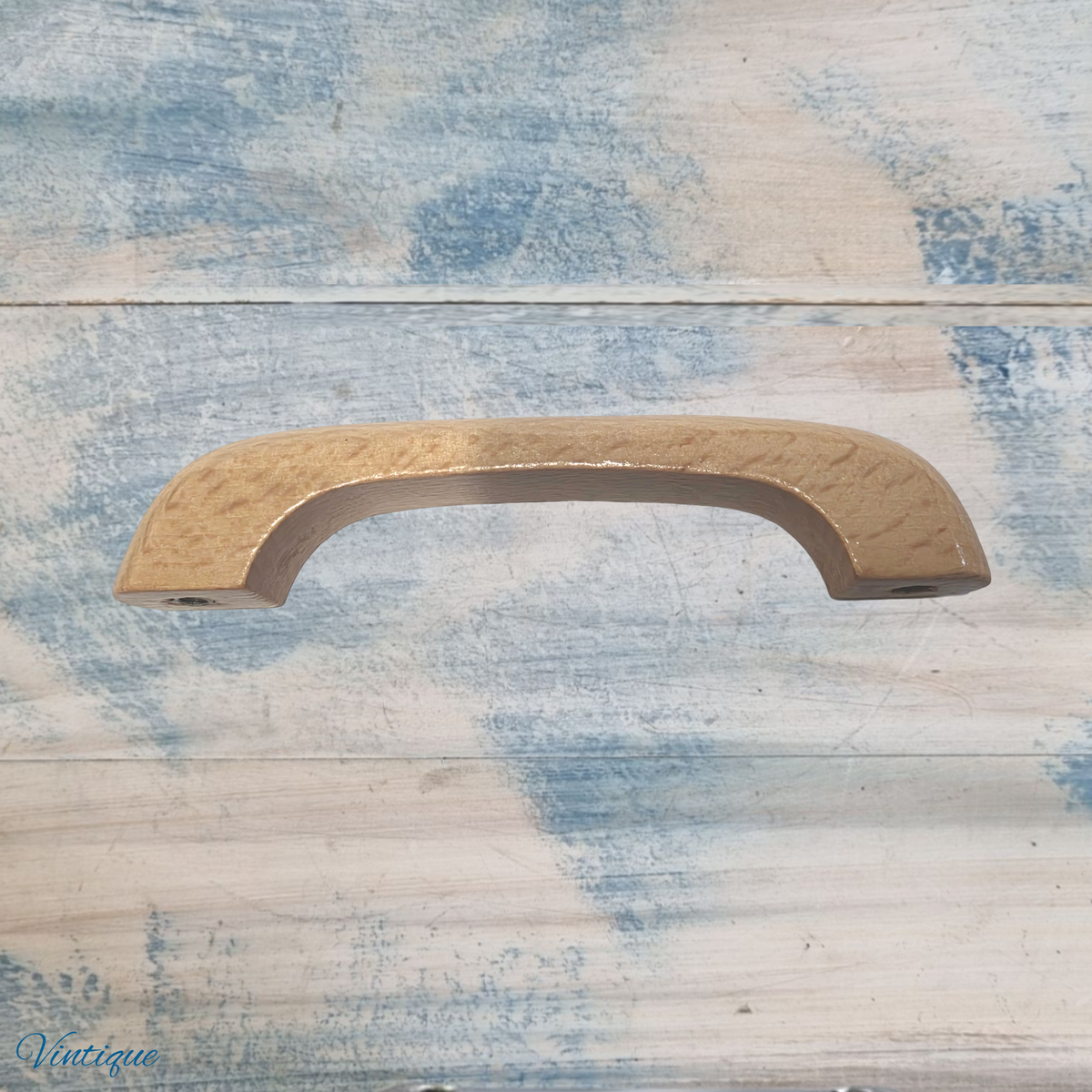 Lacquered wooden drawer knob with a smooth, curved design and a light wood finish, featuring a visible Vintique logo.